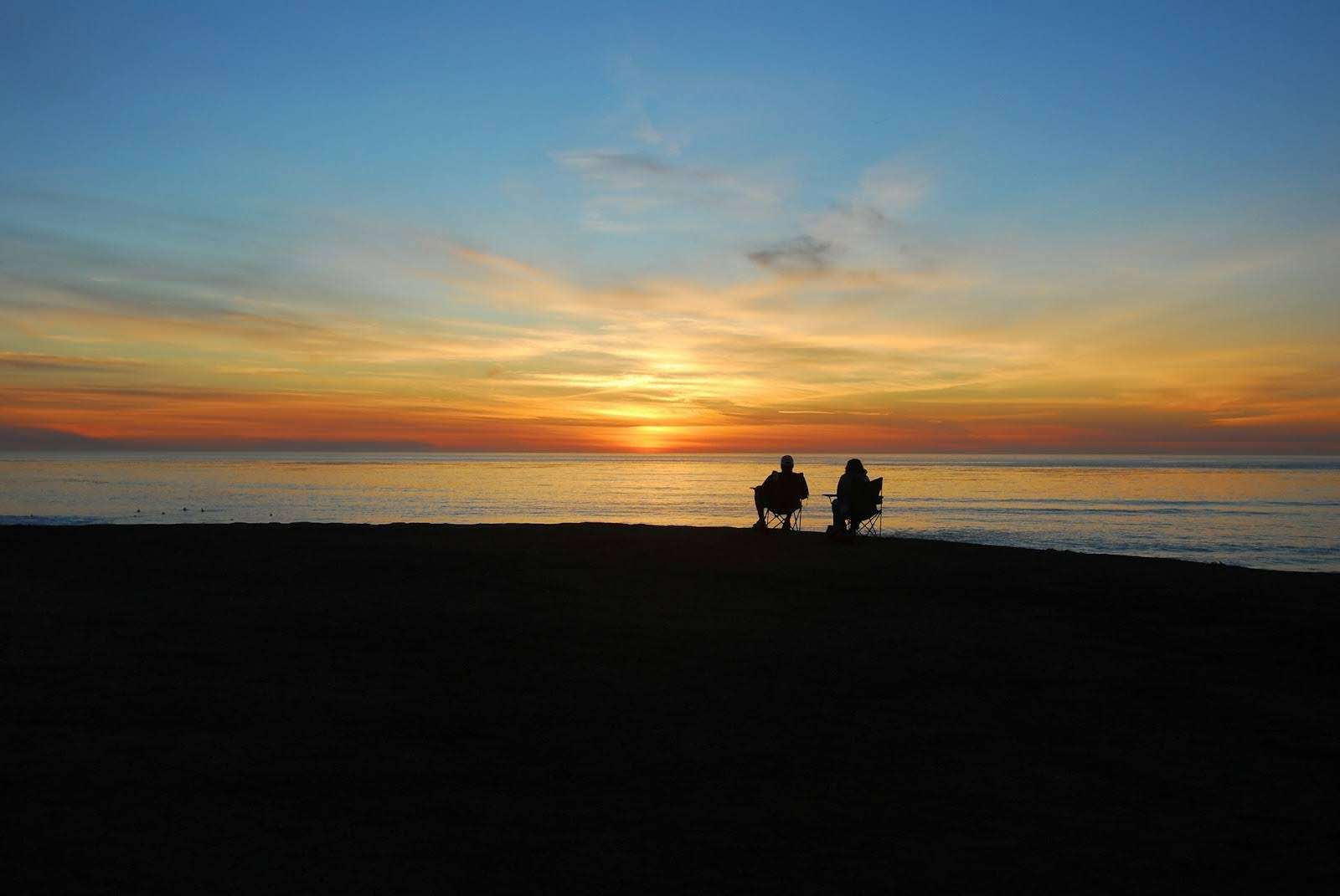 Couple on the beach at sunset — heading off into the sunset together
