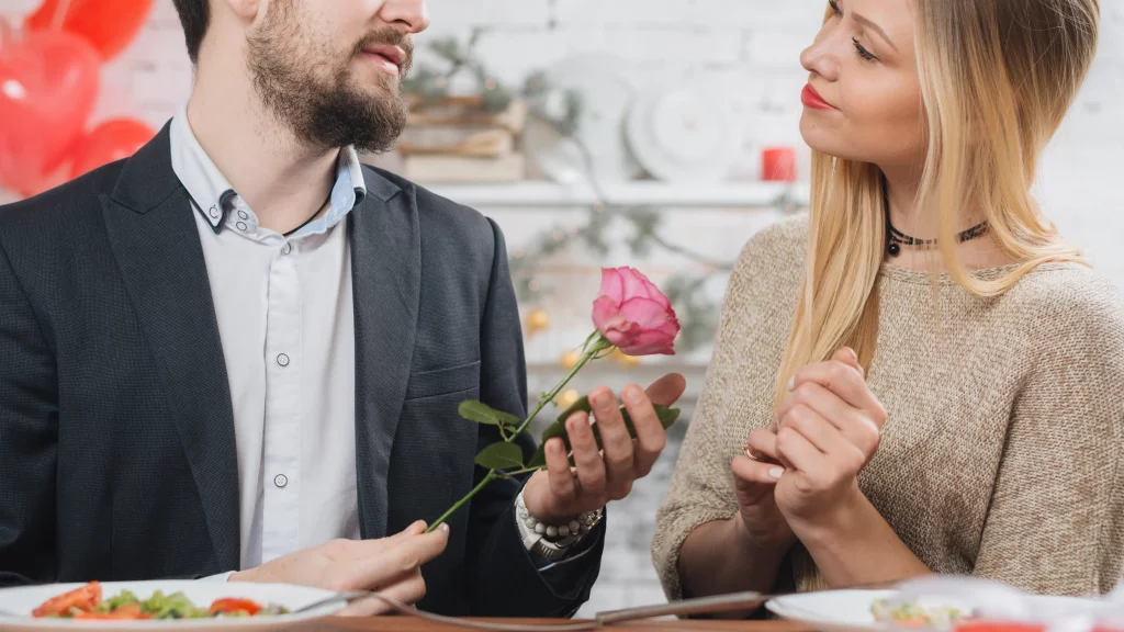 man presenting pink rose woman
