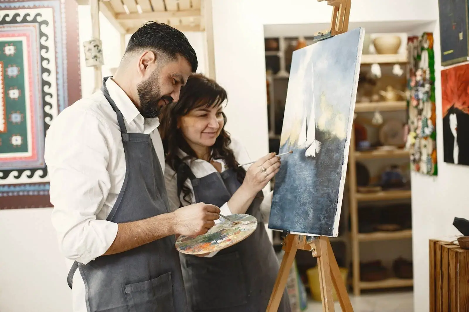 Couple painting together at an art class on a creative date