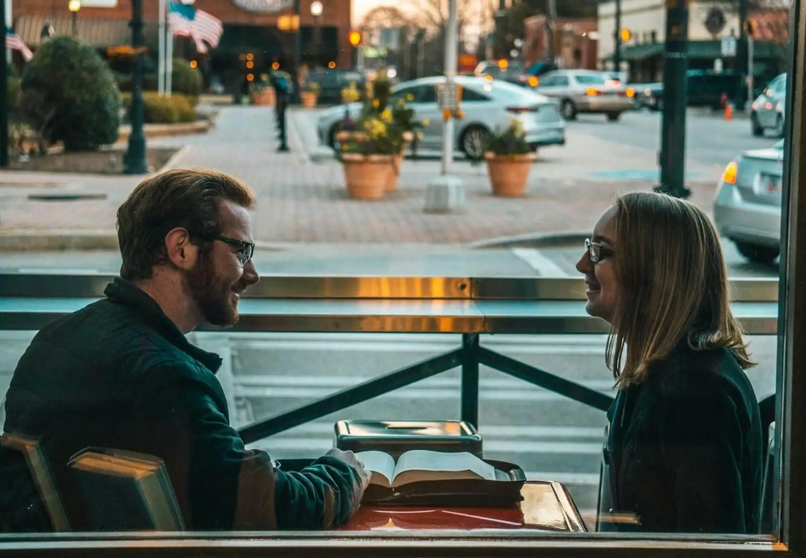 Couple in their forties talking over coffee at a window table
