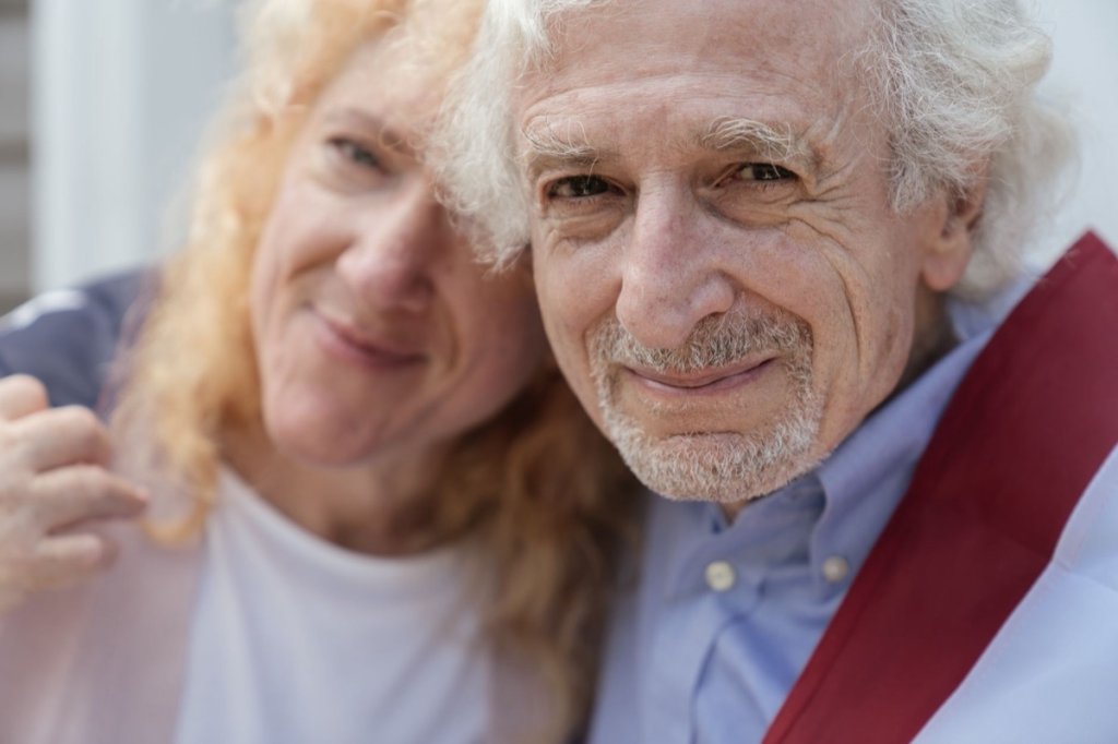An older couple smiling together, years past the first spark