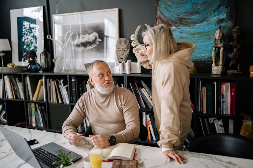 A couple in their sixties talking honestly at a table at home
